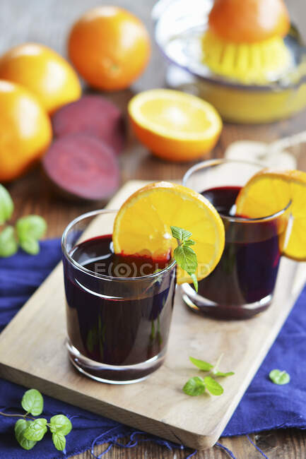 Beterraba e suco de laranja em copos — Fotografia de Stock