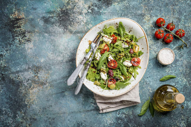 Salad with arugula, cherry tomatoes, cream cheese, pesto sauce and herbs — Stock Photo