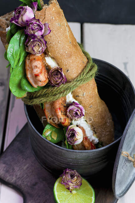Baguette sandwich with prawns and dried rose buds — Stock Photo