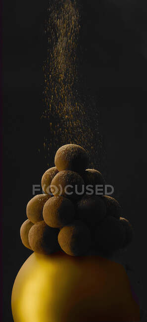 Un primer plano de una pila de caramelos de chocolate sobre un fondo negro - foto de stock