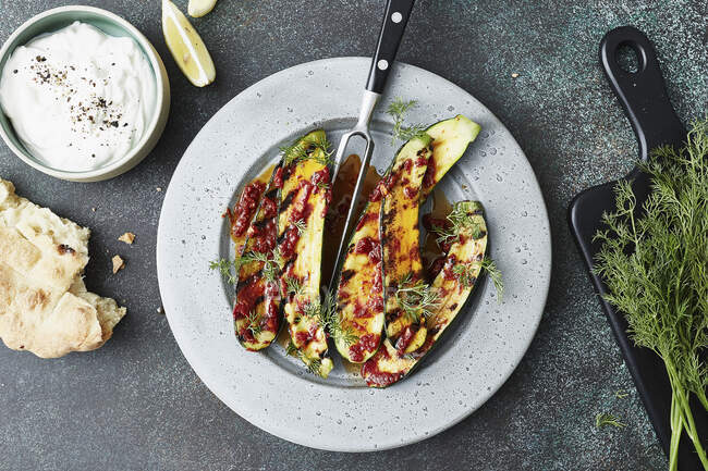 Grilled zucchini with harissa, yoghurt and flatbread — Stock Photo