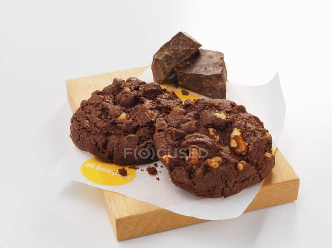 Chocolate cookies with nuts on small wooden board — Foto stock