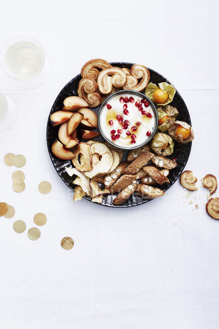 Piatto di biscotti con frutta e yogurt in tavola — Foto stock
