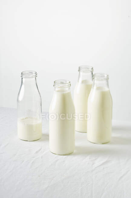 Fresh milk and jug of white and glass of different types of dairy products on a light background — Stock Photo