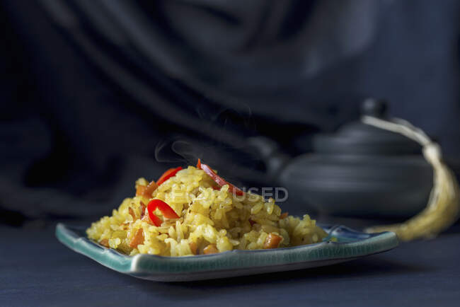 No-meat pilaf garnished with red chili peppers on a dark blue background — Stock Photo