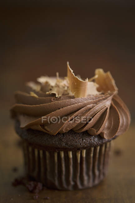 A chocolate cupcake with a cream topping and chocolate shavings — Stock Photo