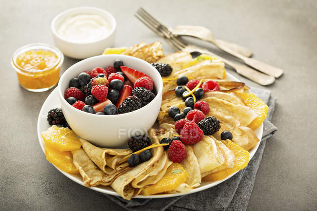 Тонкие блины со свежими фруктами и ягодами, подаваемые с мармеладом и сливочным сыром — стоковое фото