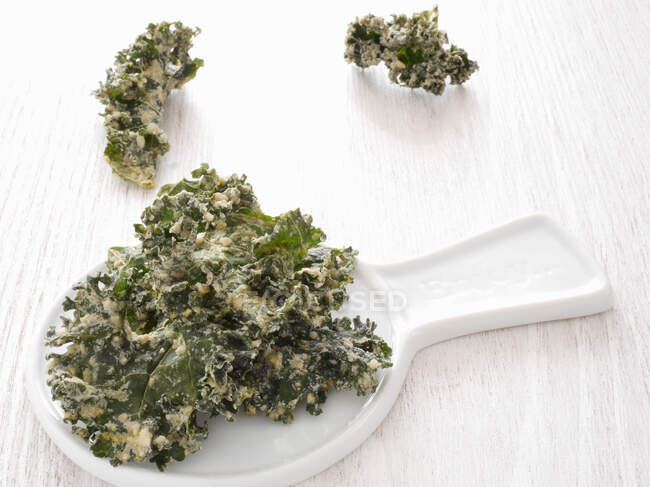 Kale chips on a white plate — Stock Photo
