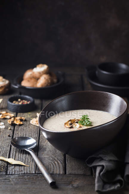 Mushroom cream soup in a bowl over dark wooden background — Stock Photo
