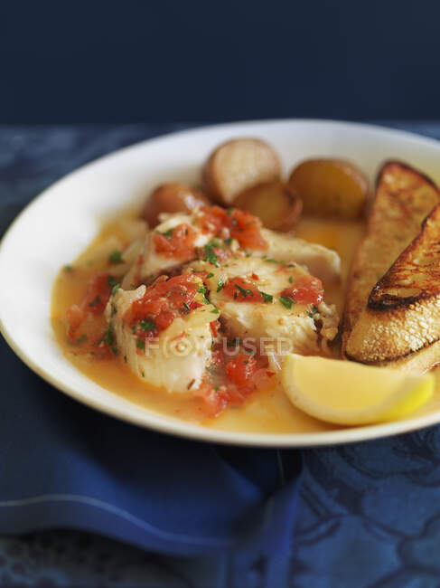Peixes escalfados com batatas e tomate e ervas — Fotografia de Stock