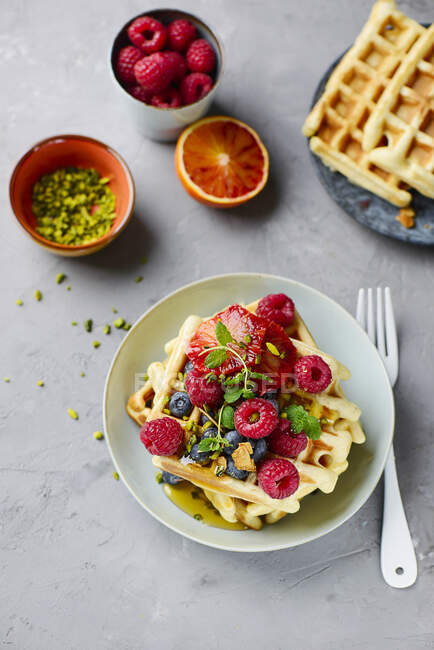 Waffles de banana com bagas frescas, laranjas de sangue e pistácios — Fotografia de Stock
