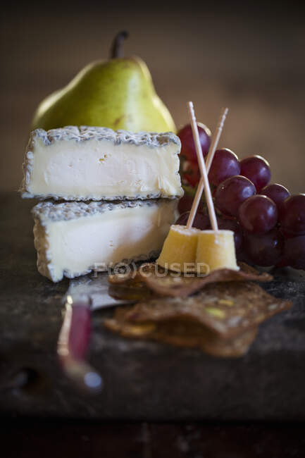 Fromage de chèvre aux craquelins, raisins et poires — Photo de stock