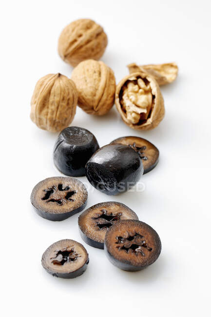 Walnuts, fresh and pickled, against a white surface — Stock Photo