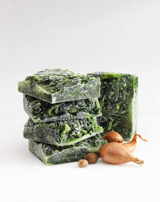 Creamed spinach, frozen in blocks against a white background — Stock Photo