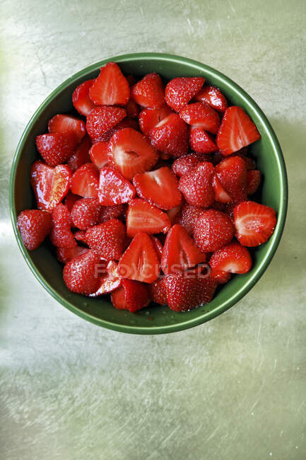 Frisch geschnittene Erdbeeren in grüner Keramikschale — Stockfoto