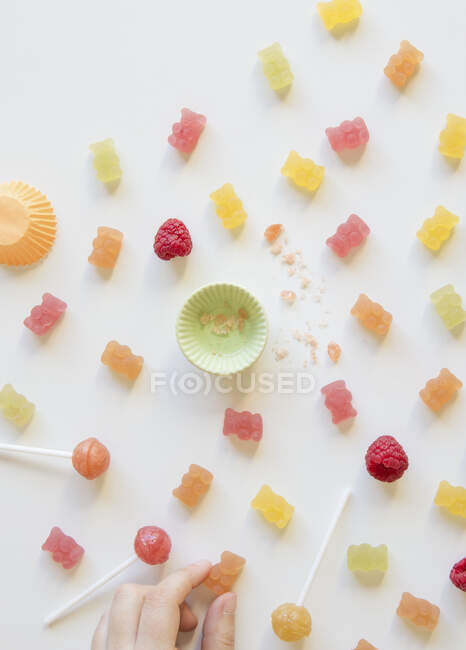 Varios dulces con la mano de un niño - foto de stock