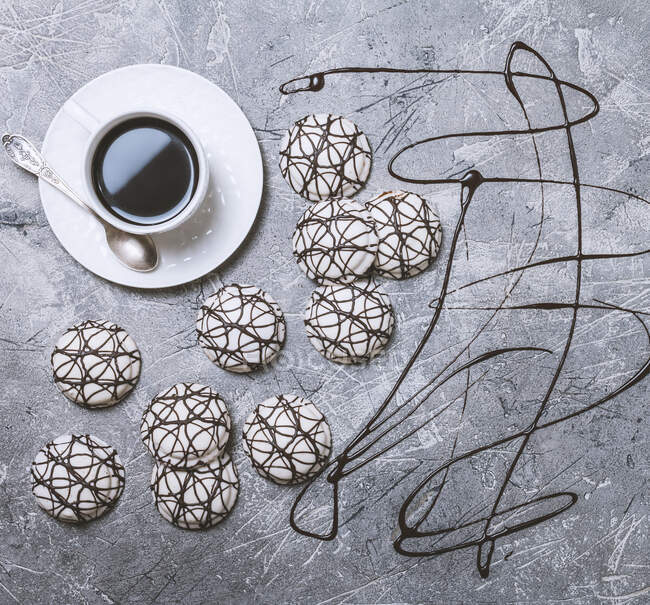 Tasse heißen Kaffee und Kekse in weißer Glasur auf altem grauen Hintergrund — Stockfoto