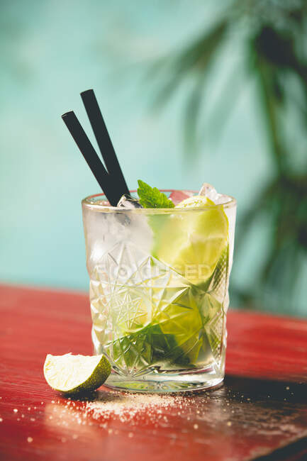 Mojito-Cocktail mit frischer Limette und Minze auf Holztisch — Stockfoto