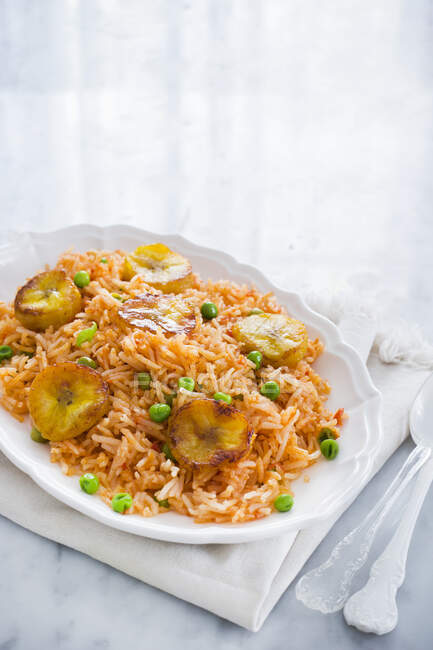 Teller mit traditionellem mexikanischen roten Reis mit Erbsen und gebratenen Kochbananen — Stockfoto