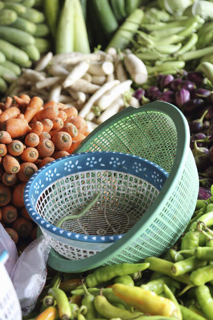 Un puesto de verduras con cuencos de plástico en primer plano - foto de stock