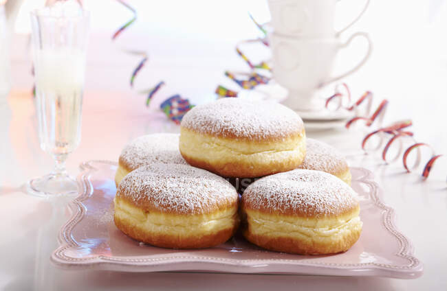 Doughnuts for carnival with streamers and a glass of champagne — Stock Photo