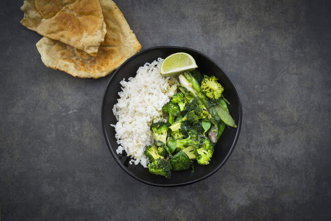 Green Thai curry with broccoli, pak choy, mange tout, baby spinach, lime and rice — Stock Photo