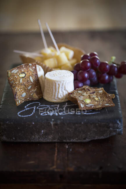 Козий сыр с цельнозерновым хлебом и виноградом — стоковое фото