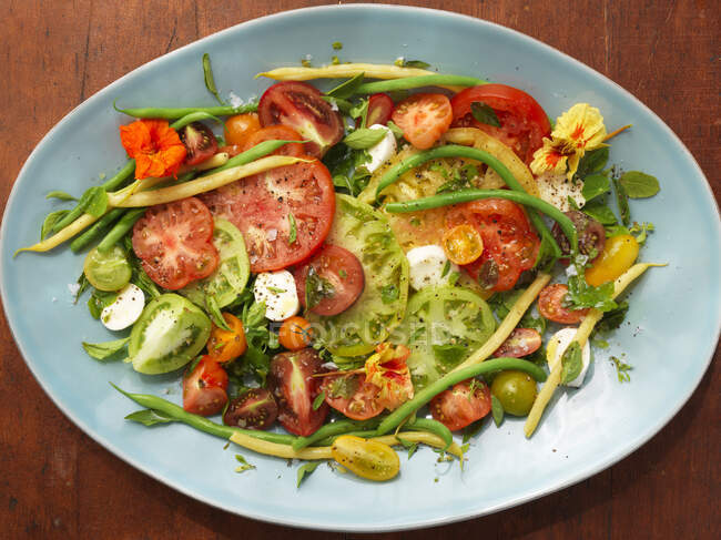 Mixed tomato salad with beans and mozzarella (top view) — Stock Photo