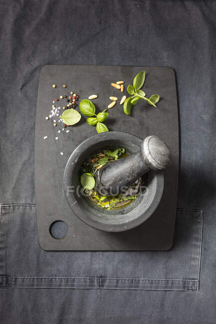 Mortar and pestle with herbs, olive oil and garlic — Stock Photo
