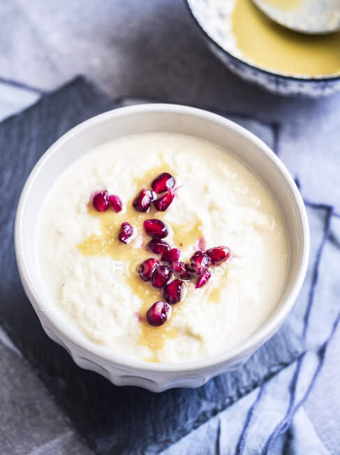 Cream of cauliflower soup with pomegranate seeds and tahina sauce — Stock Photo