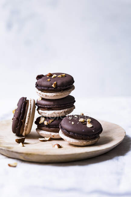 Nougat macarons with hazelnuts on wooden board — Stock Photo