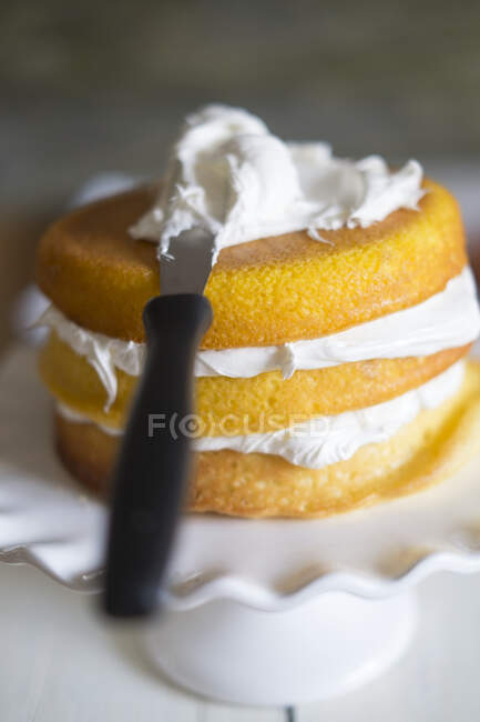 Layer Cake with cream and knife — Stock Photo