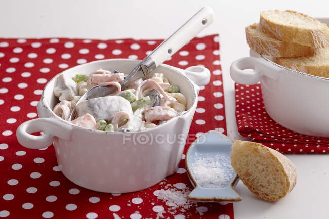 Spicy soused herring and pasta salad with slices of baguette — Stock Photo