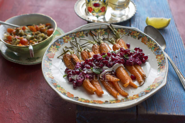 Roasted carrots with a beetroot and pomegranate sauce and peppermint — Stock Photo