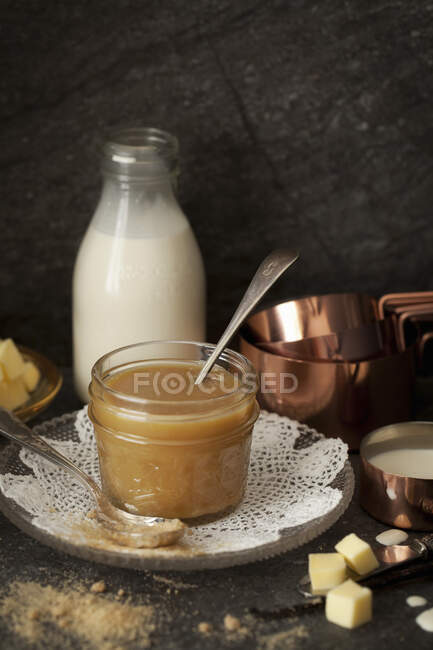 Sauce caramel maison entourée de ses ingrédients — Photo de stock