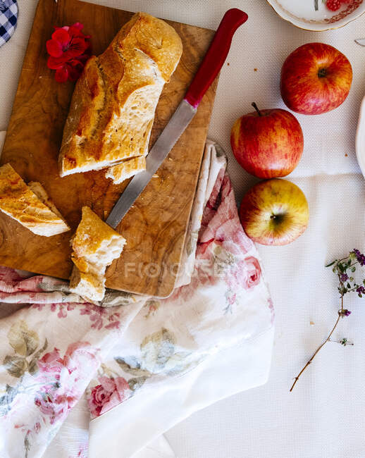 Una baguette y manzanas frescas - foto de stock