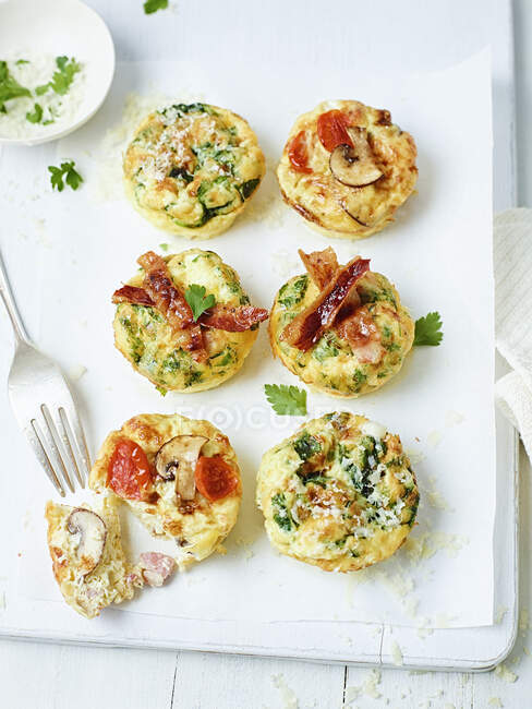 Frittata-Muffins mit Speck, Tomaten, Pilzen und Zucchini — Stockfoto
