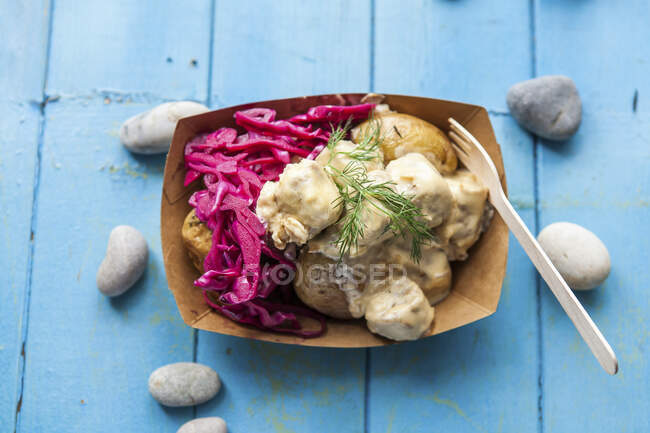 Fried potatoes with pickled cabbage and dill in paper container — Stock Photo