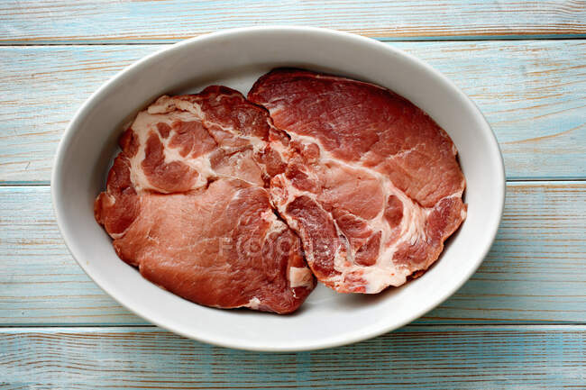 Filetes de cuello de cerdo crudo en un tazón - foto de stock