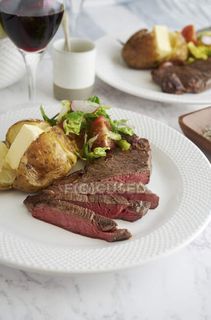 Steak de surlonge avec pommes de terre cuites au four et salade — Photo de stock