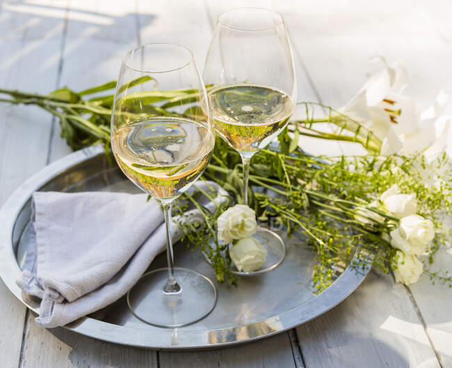 Vasos de vino espumoso en la mesa al aire libre con - foto de stock