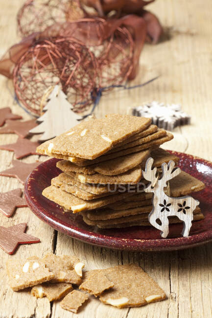 Biscotti di mandorle su piatto di ceramica con decorazioni festive — Foto stock