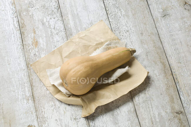 Una calabaza de mantequilla sobre una mesa de madera rústica - foto de stock