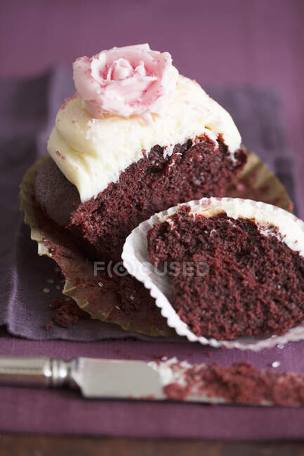 Media magdalena de chocolate con crema de vainilla y una rosa de azúcar - foto de stock