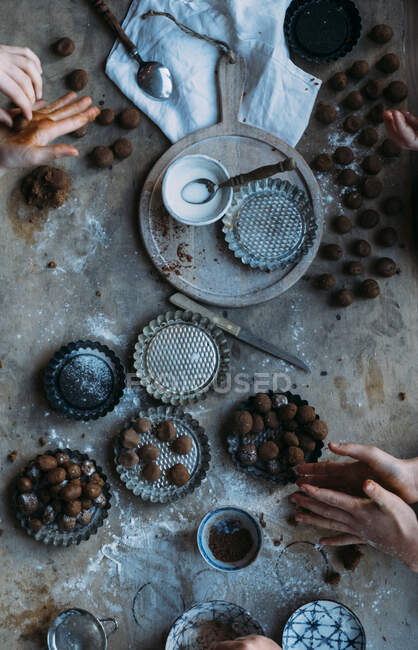 Las nueces frescas de jengibre (pepernoten en holandés) el hacer con las manos sobre la mesa - foto de stock