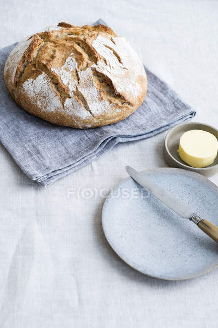 Plan rapproché de délicieux pain au levain sur un avec du beurre — Photo de stock
