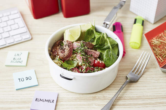 A steak bowl with spinach for an office lunch — Stock Photo