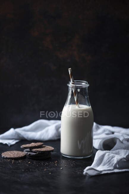 Gâteaux d'avoine végétaliens et une bouteille de lait d'avoine — Photo de stock