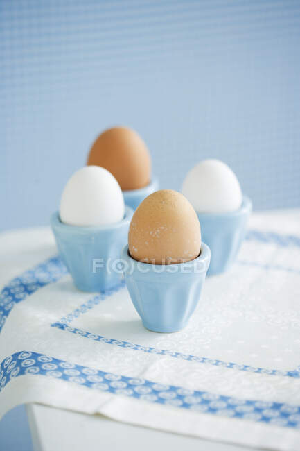 Quatre œufs dans des tasses à œufs — Photo de stock