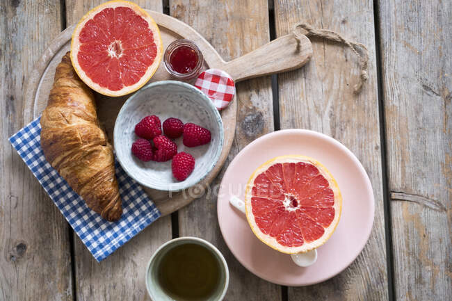 Сніданок з круасанами, варенням, малиною та половинками грейпфрута — стокове фото